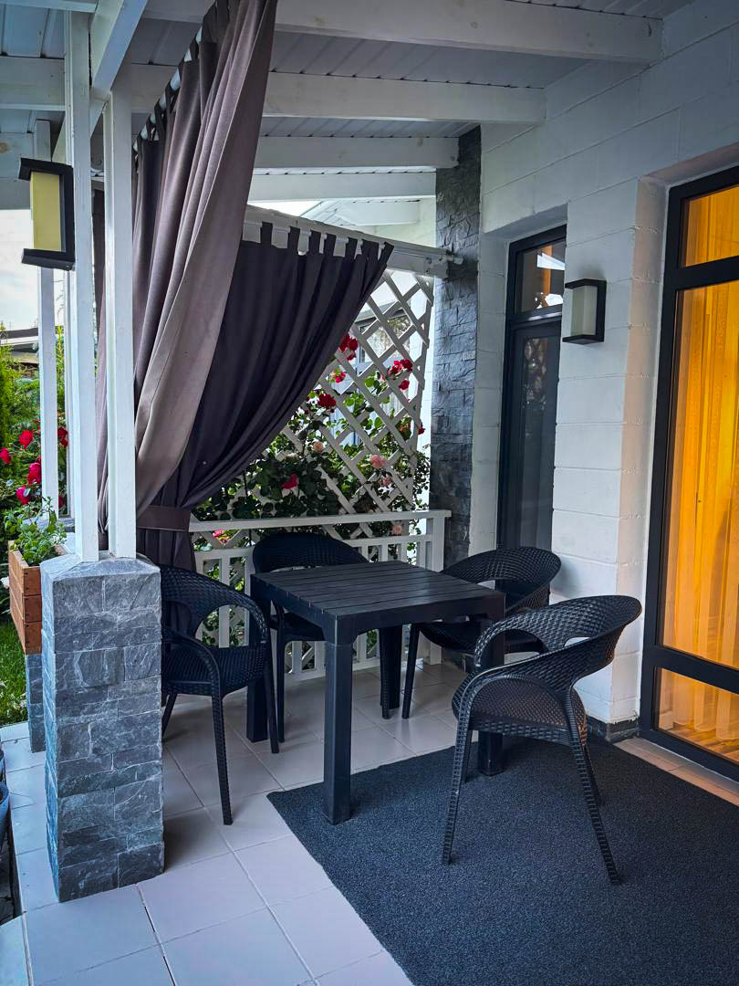 Веранда с обеденной зоной и шторами